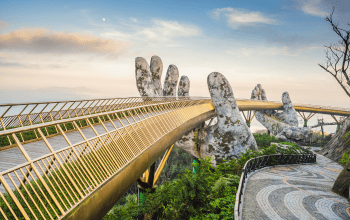 Pemandangan Golden Bridge di Ba Na Hills dengan tangan raksasa dan lanskap pegunungan
