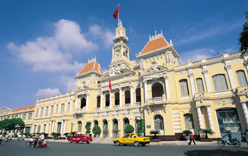 Fasada Ho Chi Minh City Hall yang megah dengan arsitektur kolonial di malam hari.